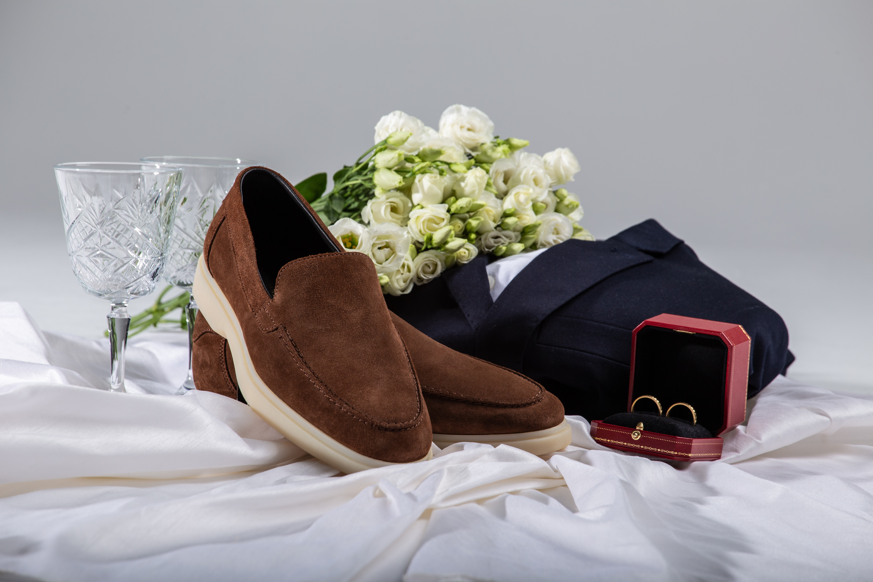 Pair of brown loafers with wedding attributes