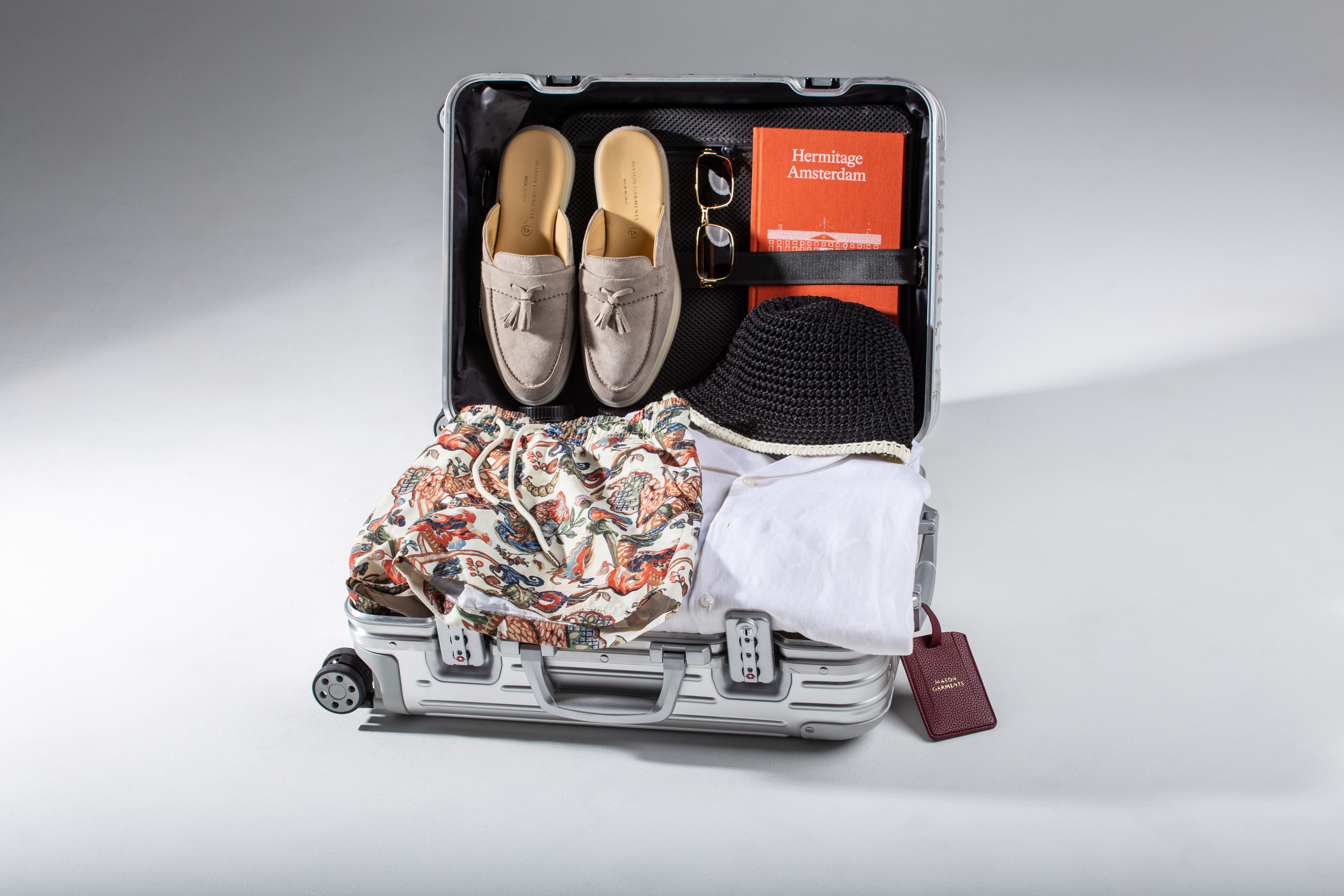 Open suitcase with beige mules and clothes inside