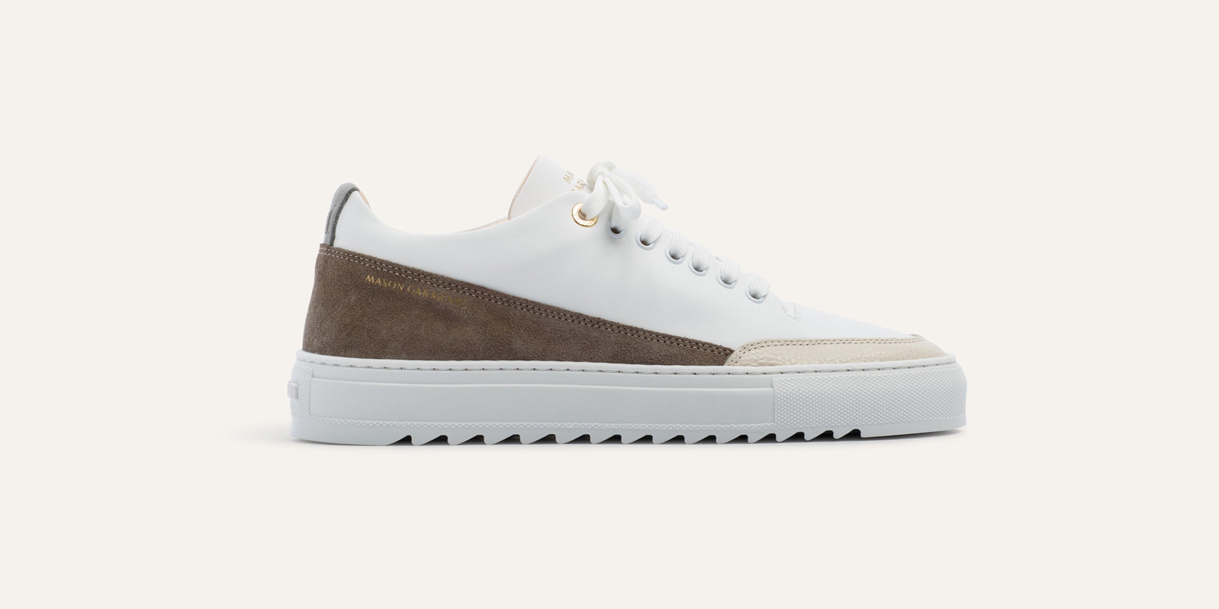 White sneaker with brown accents on a white background