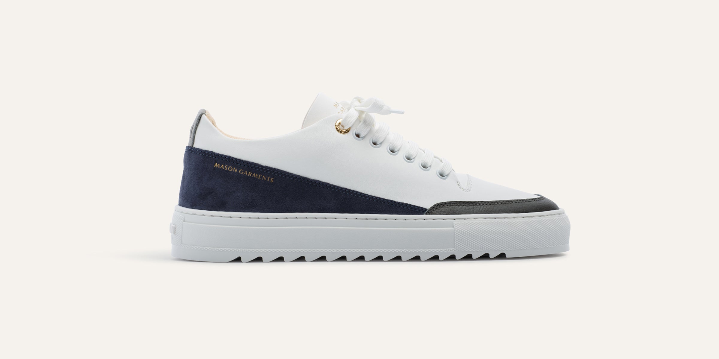 White sneaker with navy accents on a white background