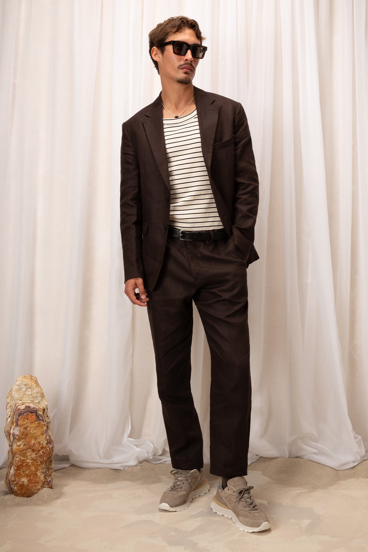 Man in brown suit and beige sneakers