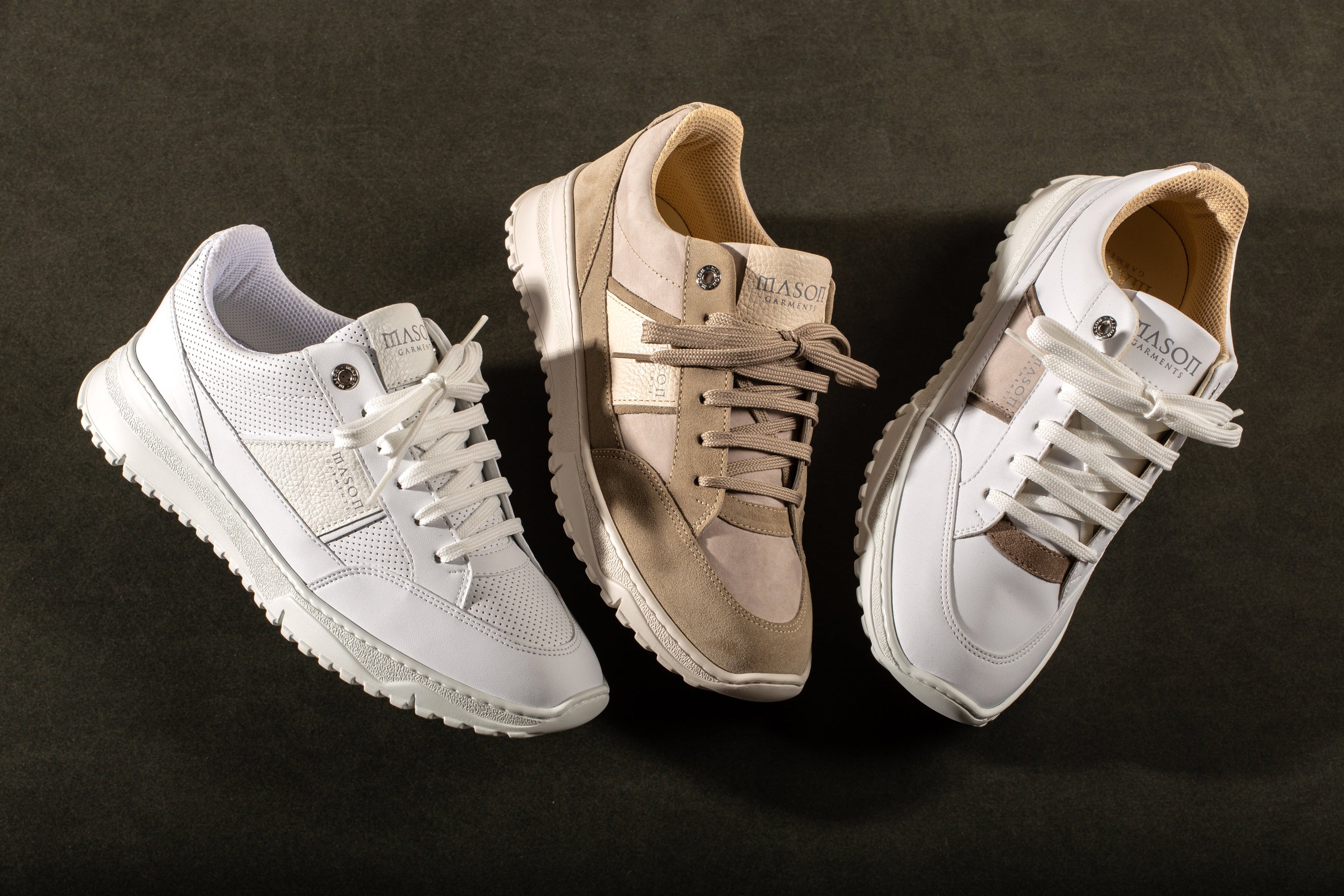 Three pairs of sneakers in different colors on a dark green background