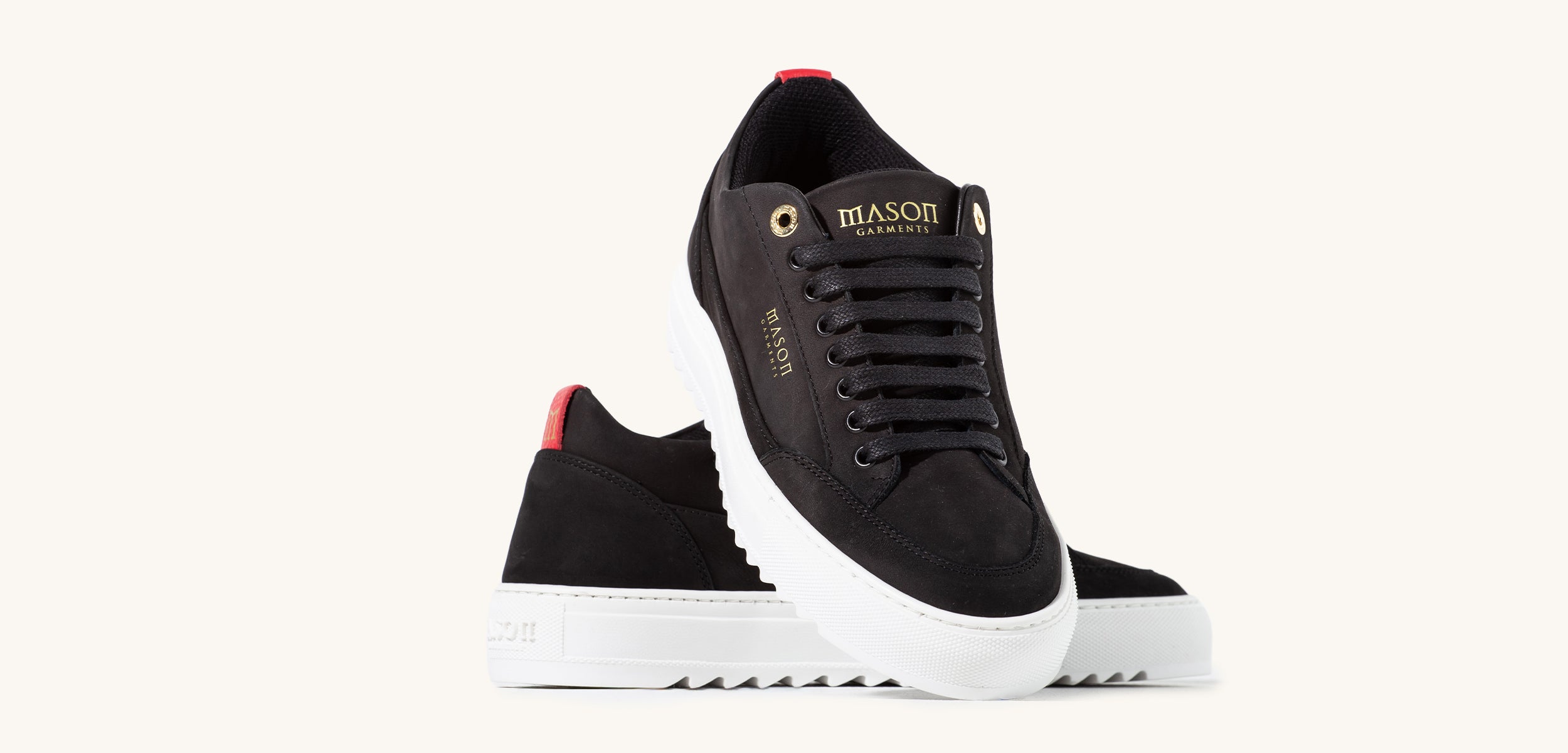 Black sneakers with white soles on a light gray background